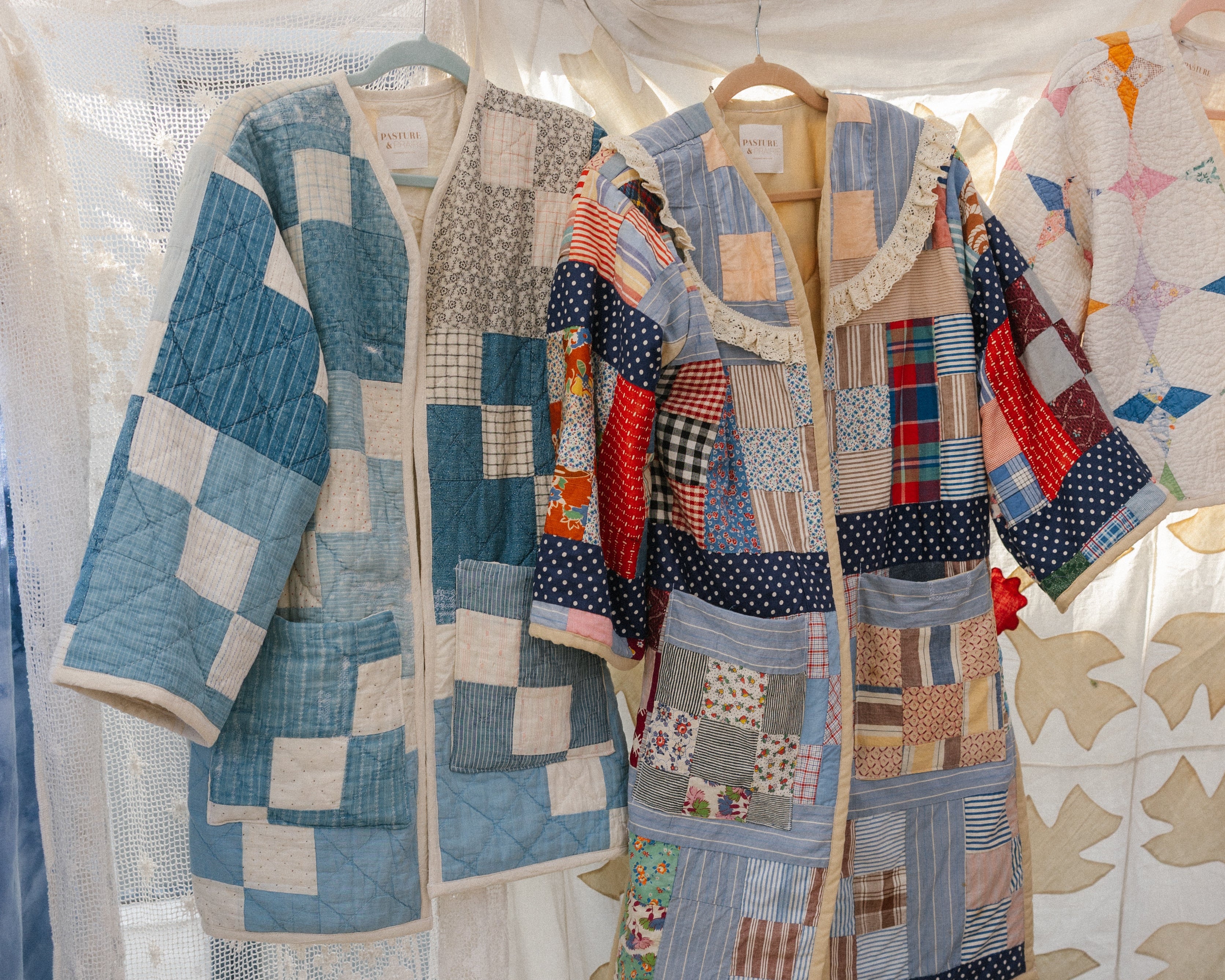 Patchwork quilt displayed under a tent with colorful patterns.