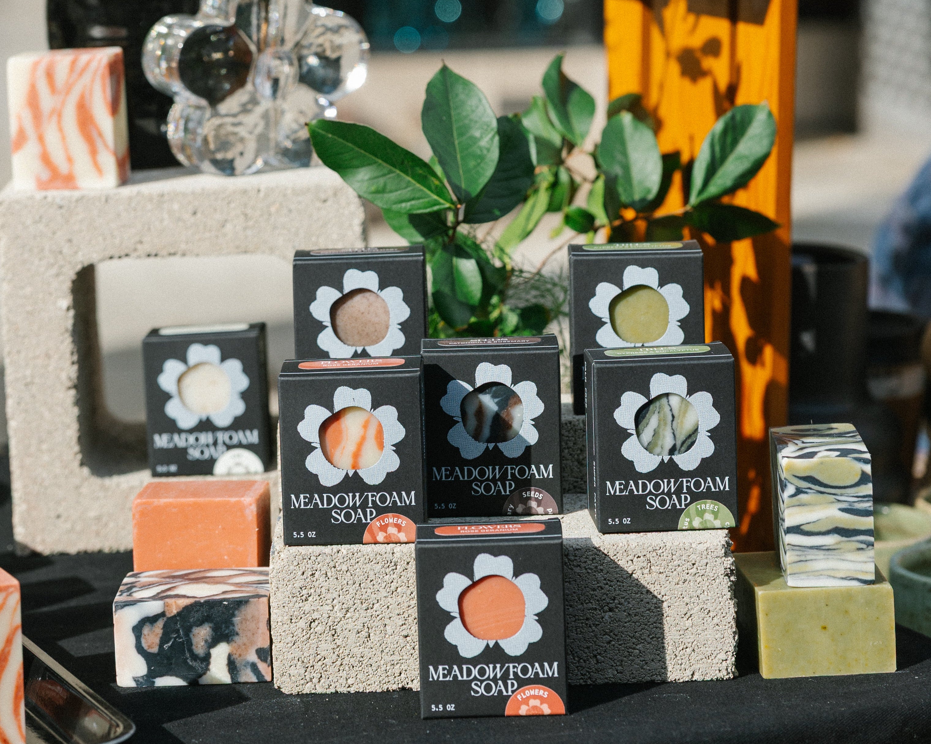 Collection of soap bars and packaging on a table with decorative elements.