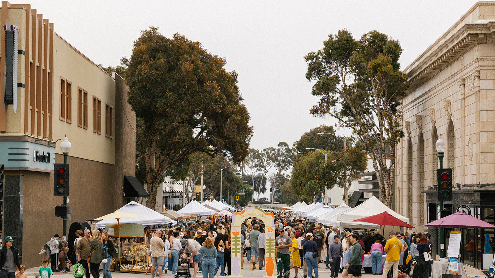Outdoor street market with stalls and people in a town setting