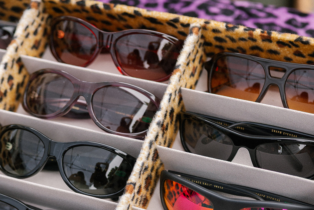 Collection of sunglasses in a leopard print case on a matching background